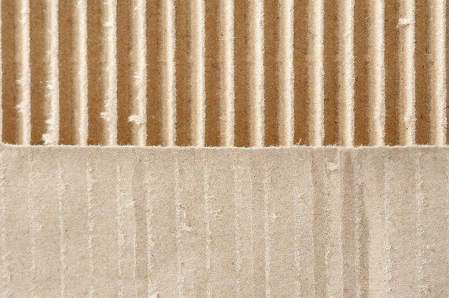 Two different brown cardboard textures each filling half the frame, one smooth and one corrugated