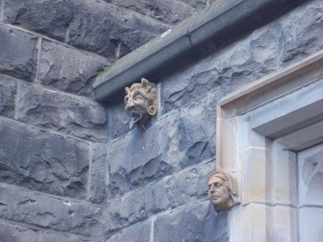 a church wall with a gargoyle and a grotesque