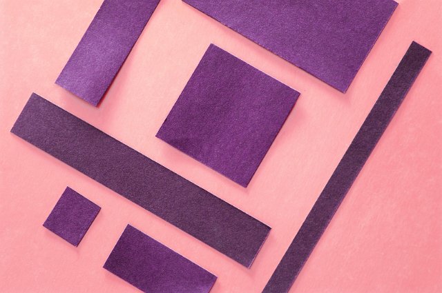 oblique angled squares of paper on a pink background