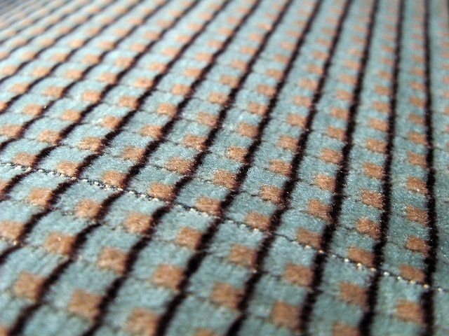 oblique view of a seat covering fabric in green and brown colours